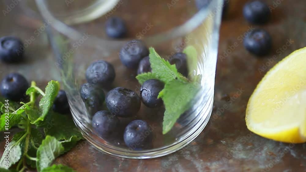 Muddling fresh blueberries and mint to make a healthy fruit drink Muddling fresh blueberries and mint to make a healthy fruit drink