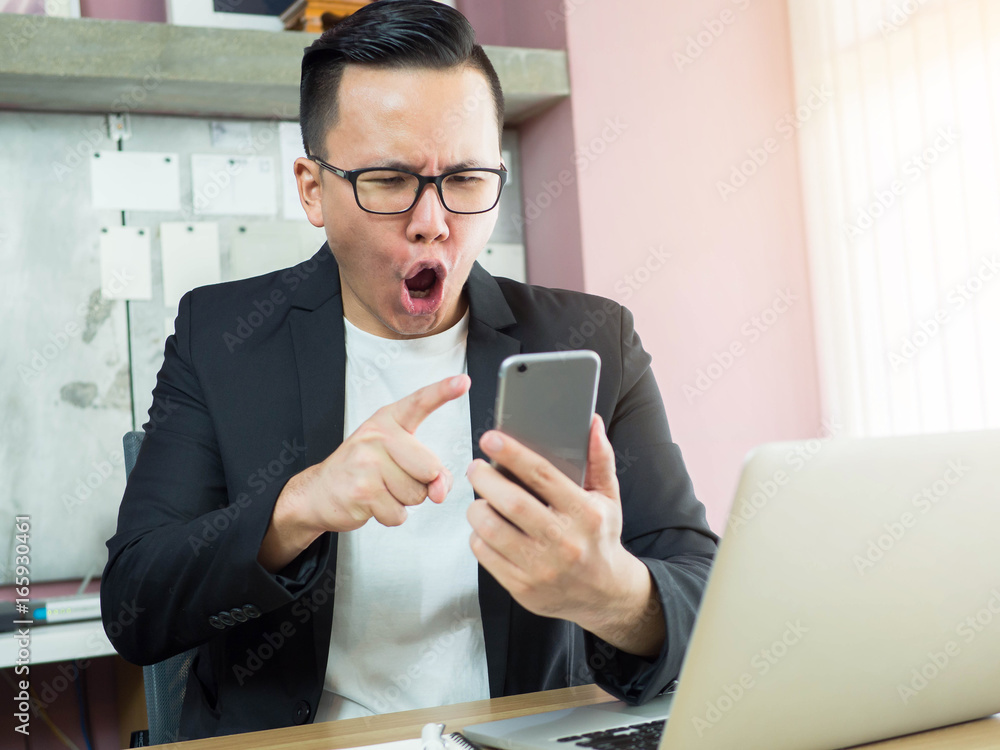Shocked businessman checking his phone Shocked businessman checking his phone