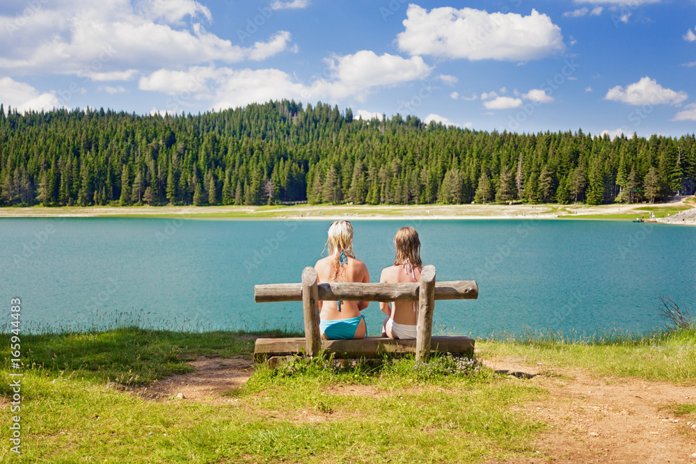 1185789 two girls on a bench near the lake 1185789 two girls on a bench near the lake