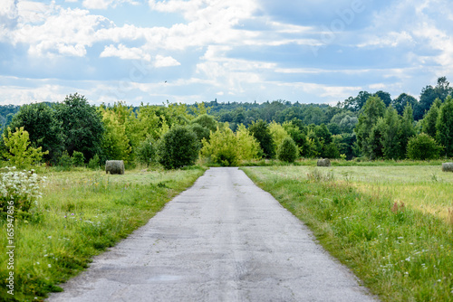 romantic gravel road in country under blue sky