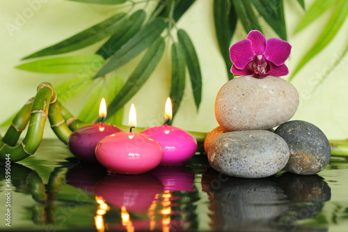 galets dispos  s en mode de vie zen sur la droite avec une orchid  e au sommet et des bougies roses allum  es