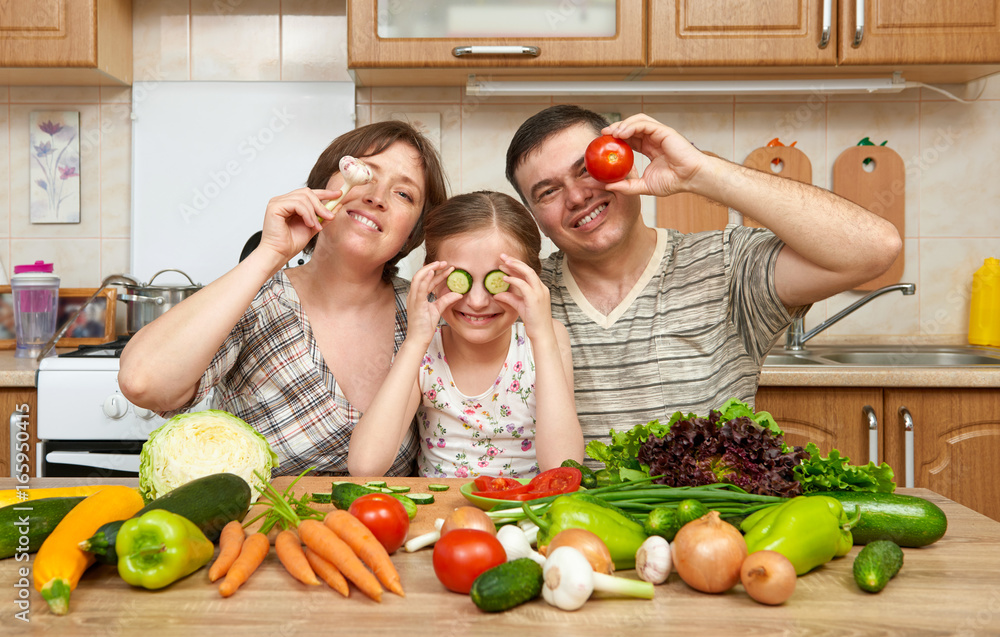 family cooking in kitchen interior at home, fresh fruits and vegetables, healthy food concept, woman, man and children family cooking in kitchen interior at home, fresh fruits and vegetables, healthy food concept, woman, man and children