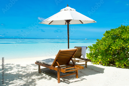 Beautiful landscape with sunbeds and umbrellas on the sandy beach, Maldives island © Myroslava