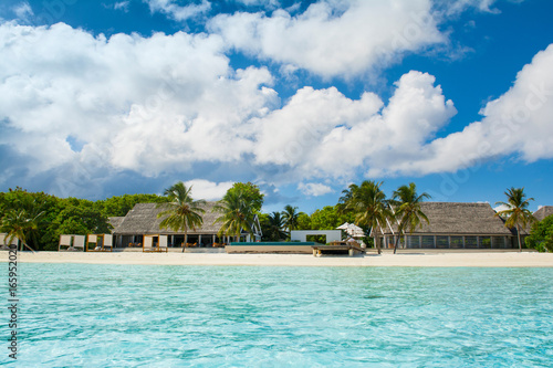 Fototapeta Naklejka Na Ścianę i Meble -  Beautiful sandy beach with sunbeds and pool in Indian ocean, Maldives island
