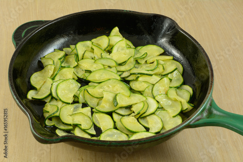 Sauteed sliced zucchini in cast iron frying pan skillet