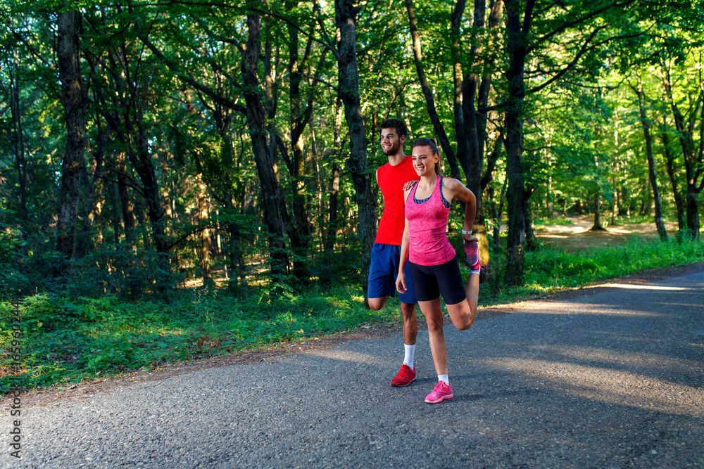 Young couple stretching his muscles outdoors before running. Young couple stretching his muscles outdoors before running.