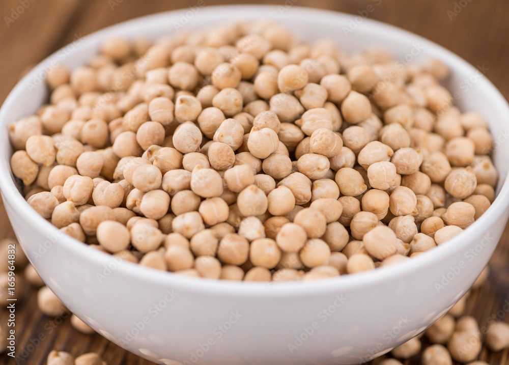 Portion of dried Chickpeas on wooden background, selective focus Portion of dried Chickpeas on wooden background, selective focus