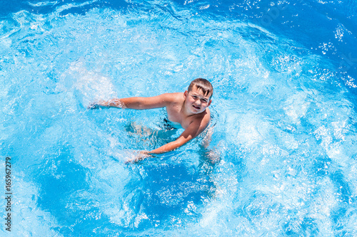 Young boy kid child eight years old splashing in swimming pool having fun © cone88