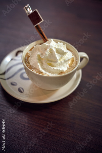 Cup of vienna coffee with cream and cinnamon on the wooden table in cafe