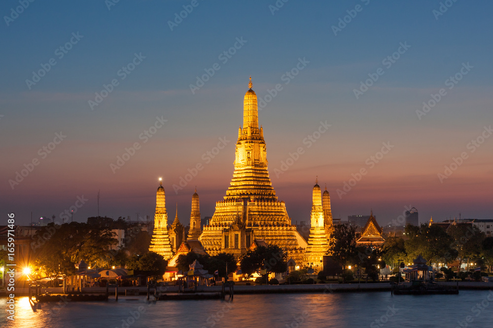 Wat Arun, located along the Chao Phraya River in Bangkok at sunset.