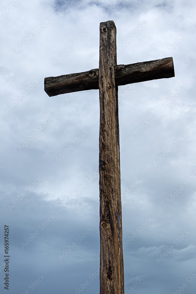 Old wood cross and cloudy sky.
