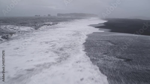 Aerial, waves crash on shoreline