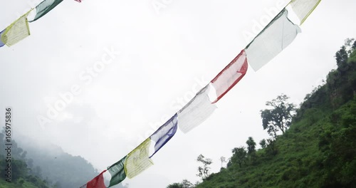 Low angle, colorful fabric on string near grassy mountains