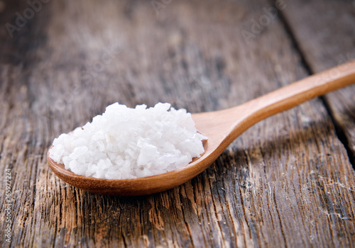 salt crystals on wooden spoon on wooden table