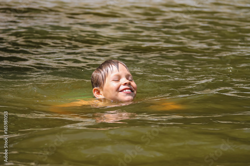 Smiling boy swimming in lake