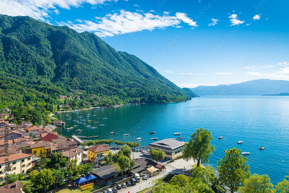 Lake Maggiore, Caldè, Italy. One of the most charming corners of the Lake Maggiore on a beautiful summer day. Aerial view of the small town, hamlet of Castelveccana, and of the small harbor