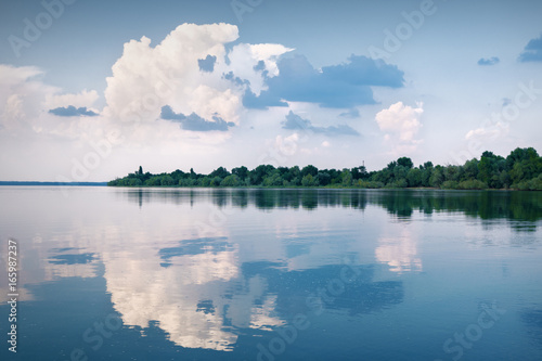 lake with clouds reflected in the water and the blue sky