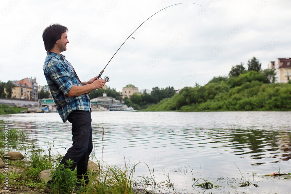 A man with a beard is fishing in the river A man with a beard is fishing in the river