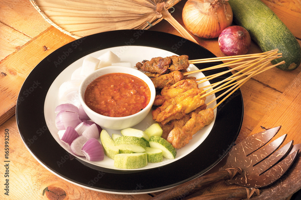 Asian food satay served with onion and cucumber