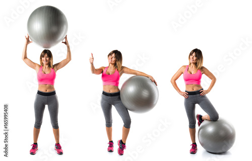 Sport woman with fit ball and with thumb up