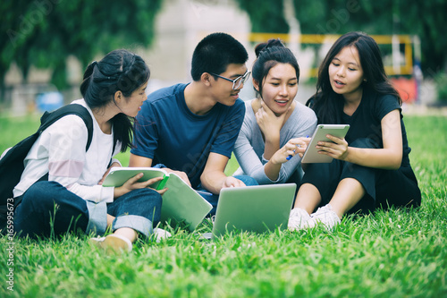 Asian Group of students sharing with the ideas for working on the campus lawn