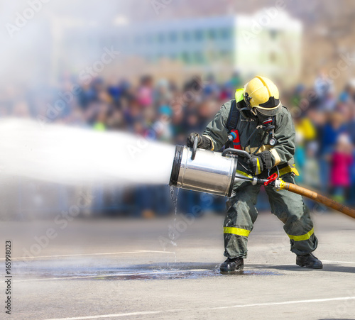 Firefighters while extinguishing the fire with a special fire extinguishing equipment. © bborriss
