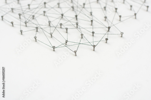 Linking entities. Network  networking  social media  internet communication abstract. A small network connected to a larger network. in paper linked together by cotton with a black tint