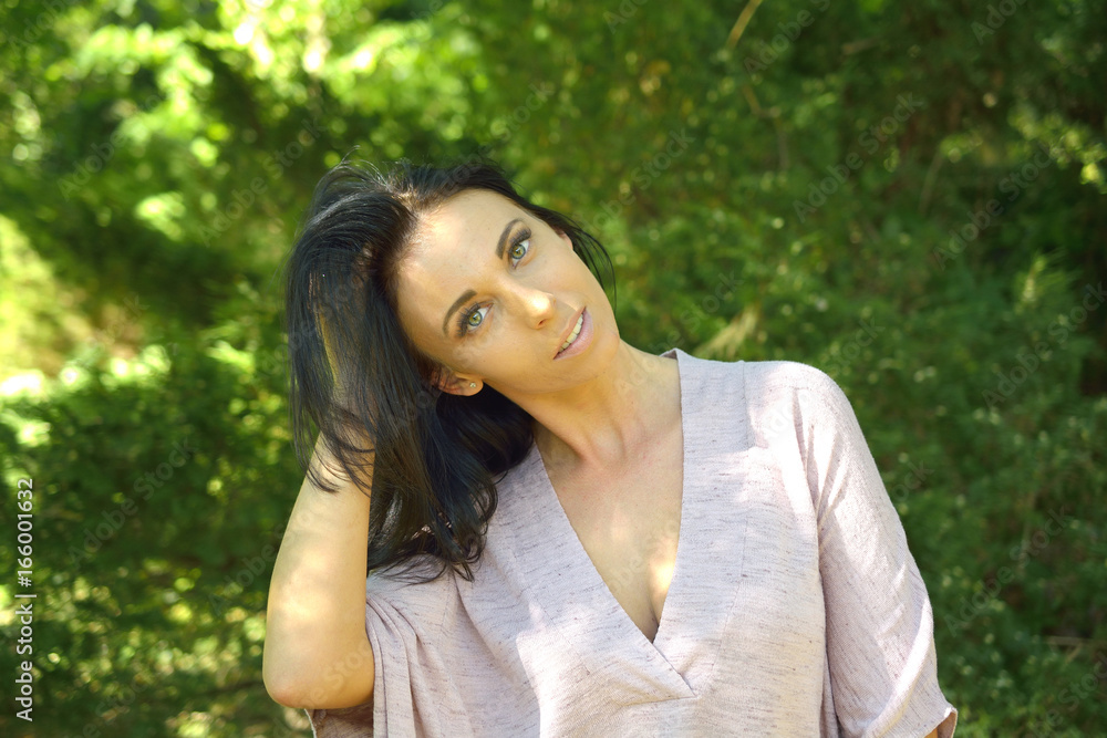 Portrait of beautiful young woman against green lawn Portrait of beautiful young woman against green lawn