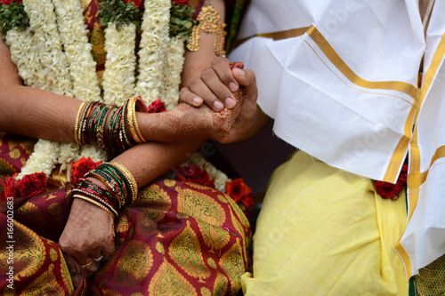Paani Grahanam ritual during a Hindu Wedding. The groom with his right hand holds the right hand of the bride. This symbolizes the bride surrendering her heart in the hands of the groom.