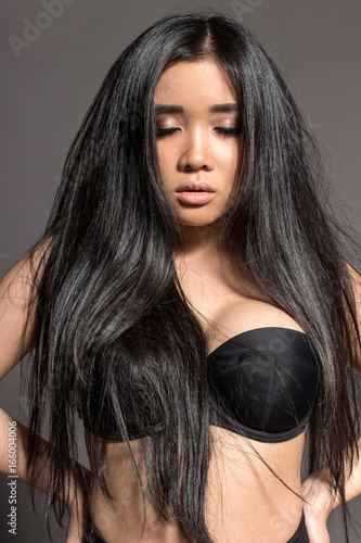 attractive Asian sexy fashion model with natural hair, full lips, perfect skin, posing in studio, wearing black underwear, beauty photo shot, retouched image