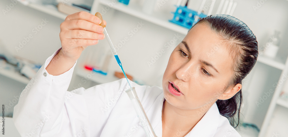 Fototapeta premium Young female scientist in lab , doing experiments in lab.