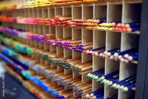 Multicolored pencils in art store in wooden cells closeup, selective focus. Artspace, workshop, creativity concept. Modern art. © gorynvd