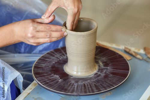 Creating jar or vase of clay. Woman hands, potter's wheel photo