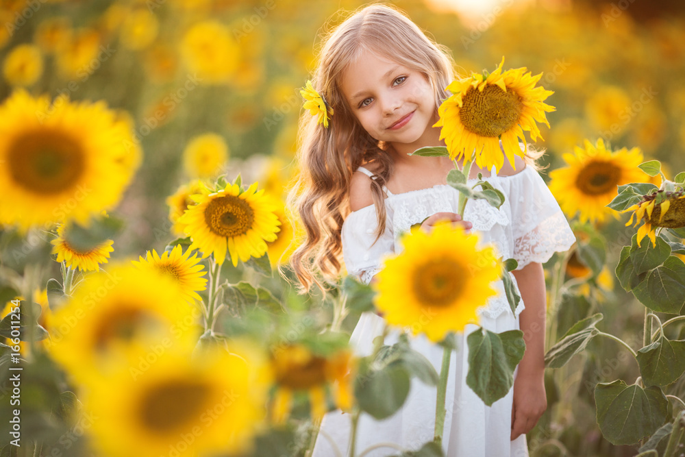 Child girl in yellow garden of sunflowers Child girl in yellow garden of sunflowers