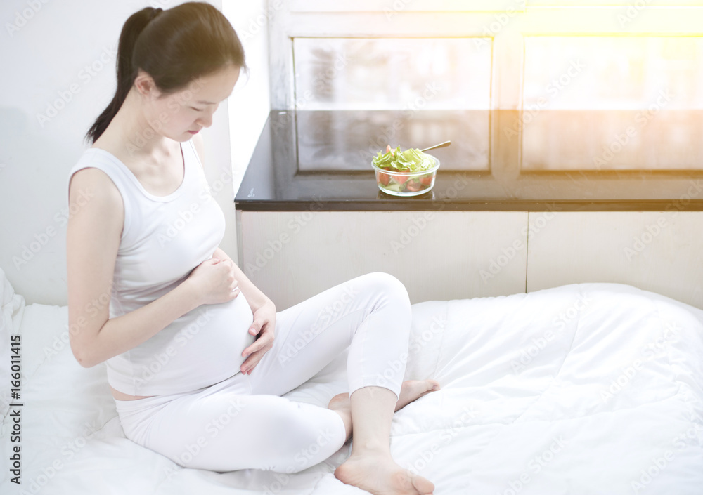 healthy nutrition and pregnancy. pregnant woman's belly and vegetable salad healthy nutrition and pregnancy. pregnant woman's belly and vegetable salad