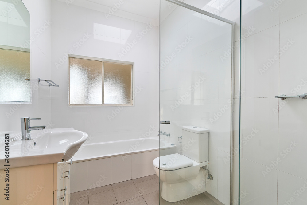 A modern bathroom with a shower area and a bathtub including a wall mirror A modern bathroom with a shower area and a bathtub including a wall mirror