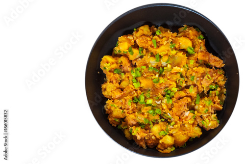 stewed meat with potatoes, onion in a frying pan. top view. isolated on white