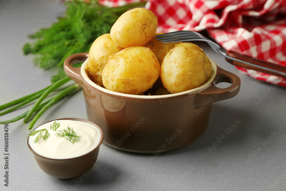 Pot with boiled potatoes, fresh herbs and sauce on table Pot with boiled potatoes, fresh herbs and sauce on table