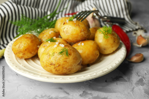 Plate with boiled potatoes on table