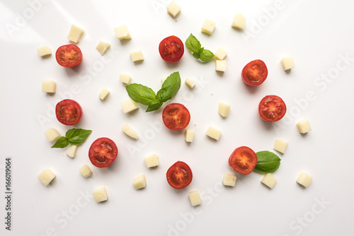 Tomatoes, cheese, Basil on a white background. Ingredients for pizza. Cute simple background, backdrop products of small size. Top view. Close-up. Stock photo Cooking concept.