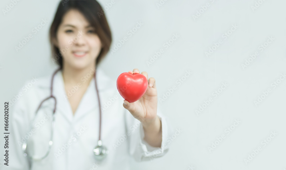 Close-up of female doctor holding red heart, in health checking concept. Close-up of female doctor holding red heart, in health checking concept.