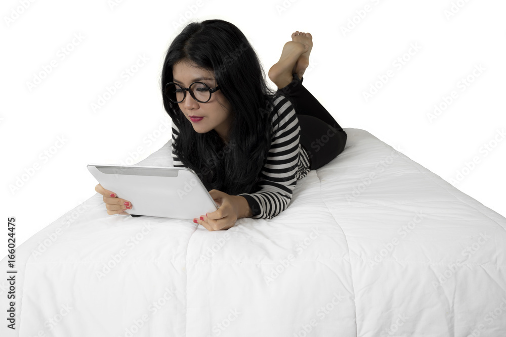 Pretty woman using digital tablet on bed Pretty woman using digital tablet on bed