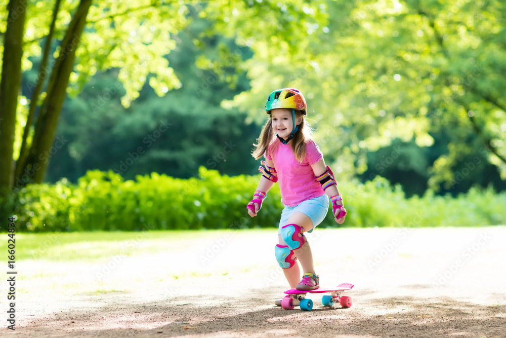 Fototapeta premium Child riding skateboard in summer park
