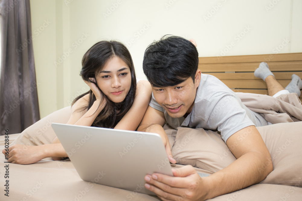 Asian couple man and woman using computer in the room. lifestyle people concept, 20s-30s age Asian couple man and woman using computer in the room. lifestyle people concept, 20s-30s age