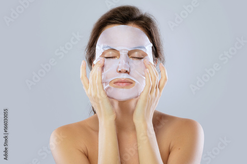 Canvas Print Woman with a cloth moisturizing mask on her face