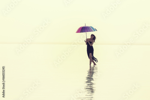 girl in the autumn forest. fairy-tale reflection in the lake. Fashionable woman standing over lake in park 