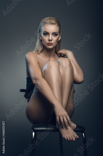 The image of a beautiful luxurious woman sitting on chair.