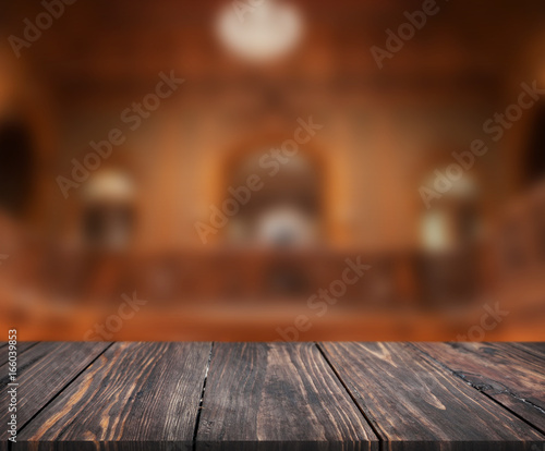 image of wooden table in front of abstract blurred background of interior. can be used for display or montage your products. Mock up for display of product.