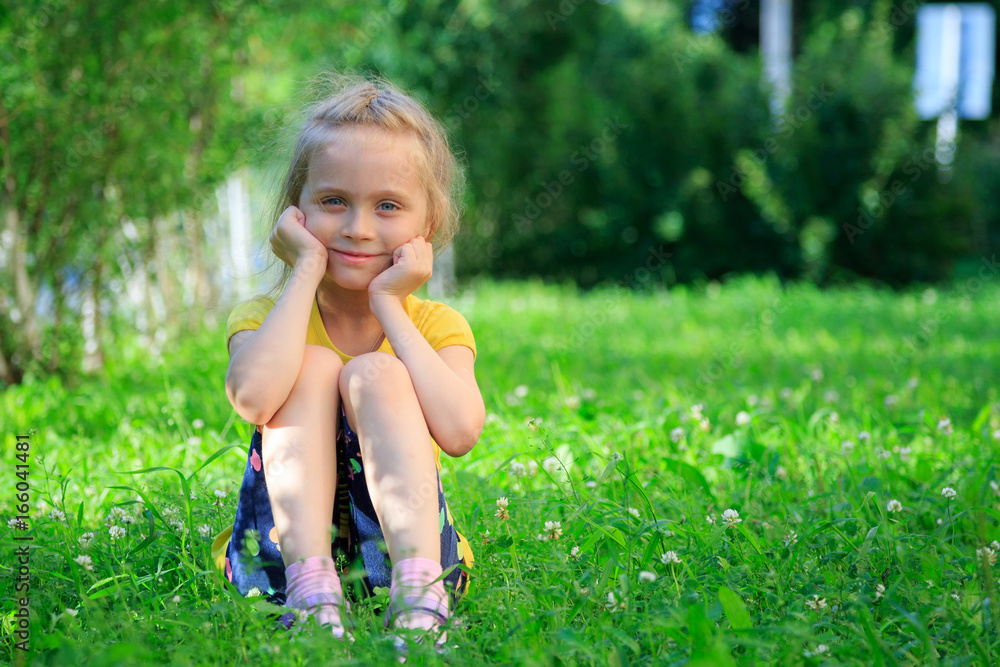 Little girl sitting in the grass Little girl sitting in the grass