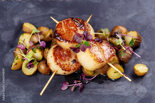 Grilled scallops with roasted young potatoes photo